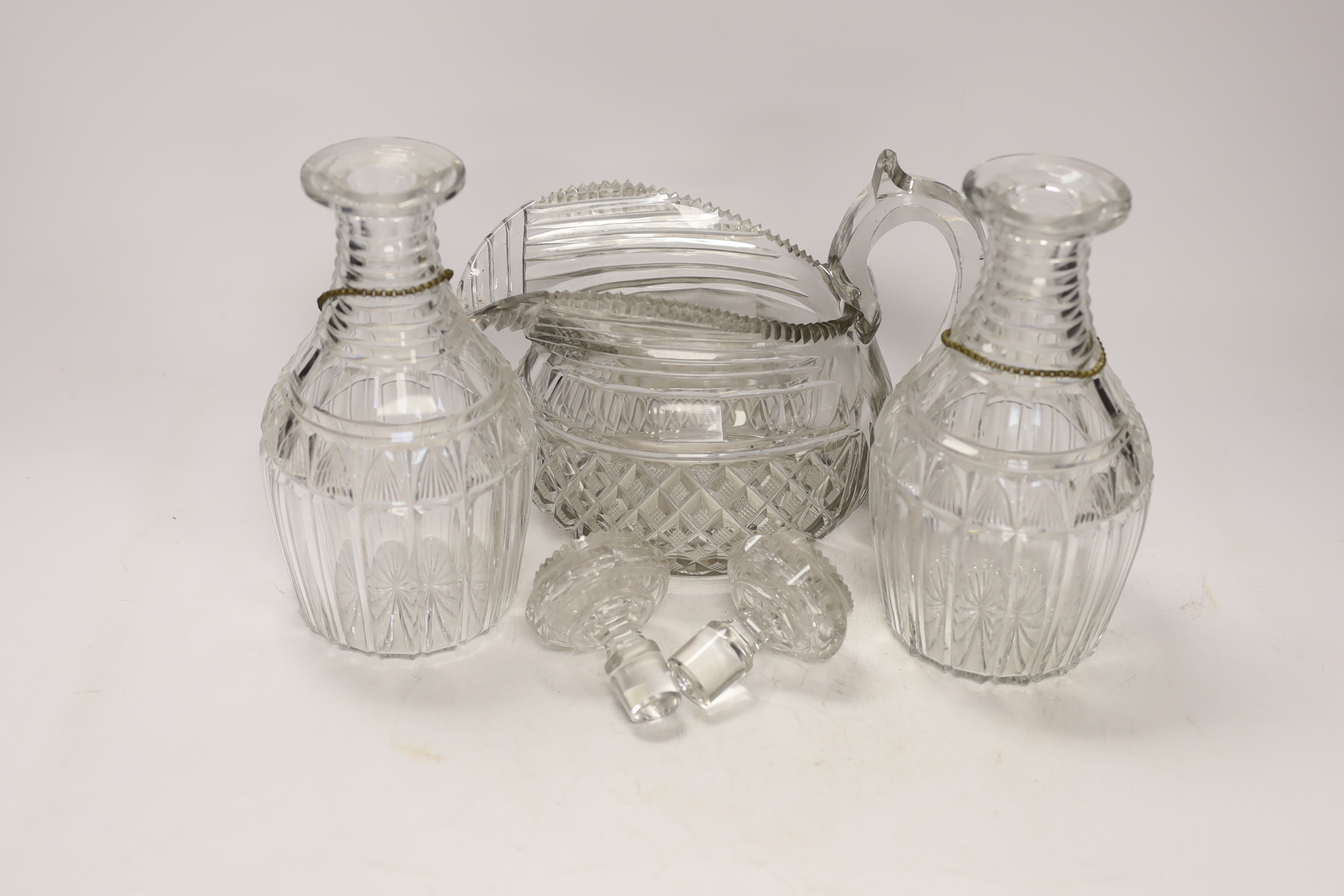 A Regency hobnail and slice cut jug and a pair of Regency cut glass mallet shaped decanters with ‘’Port’’ and ‘’Sherry’’ polychrome enamel labels, 22cm (5)